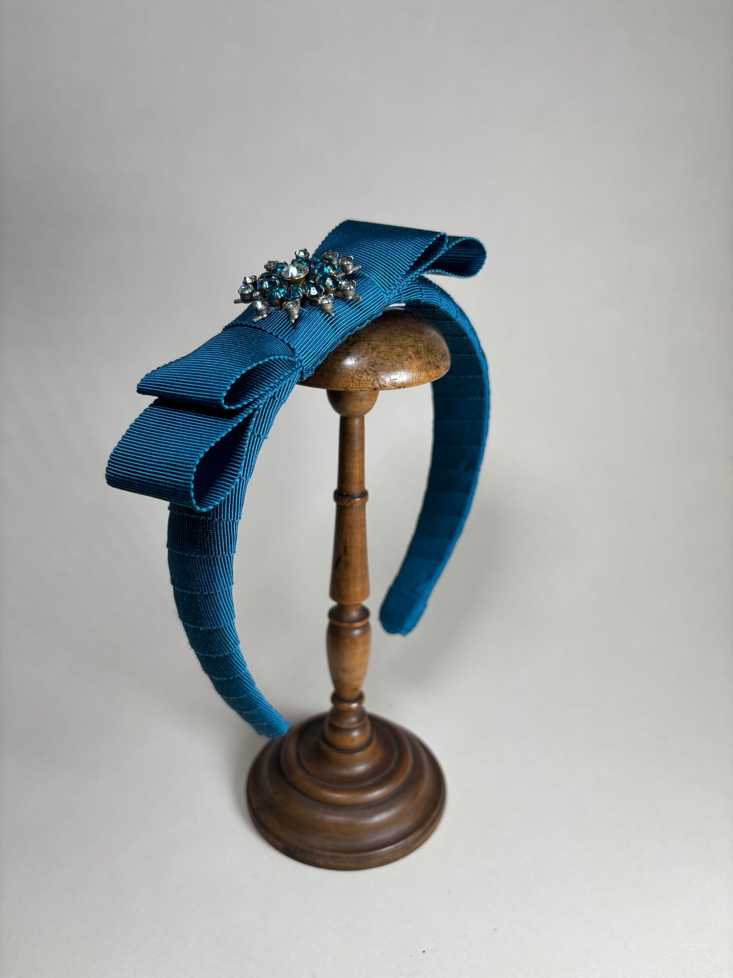 Petrol coloured headband with a unique floral brooch