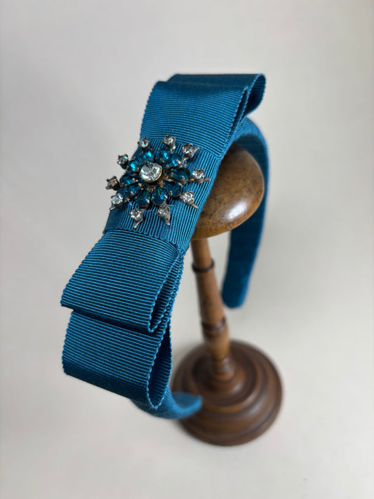 Petrol coloured headband with a unique floral brooch