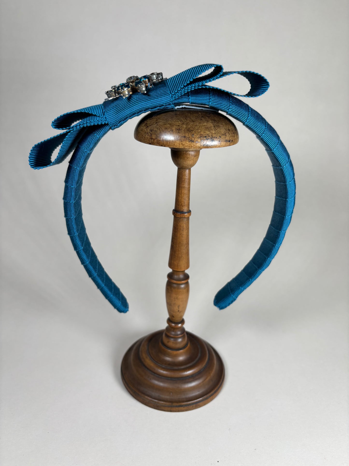 Petrol coloured headband with a unique floral brooch